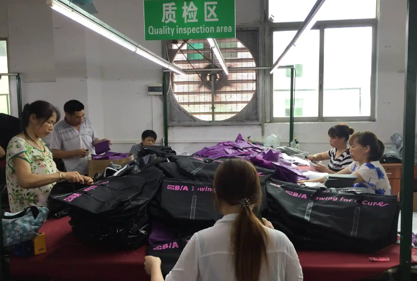 Staff inspecting bags in the marked quality inspection area